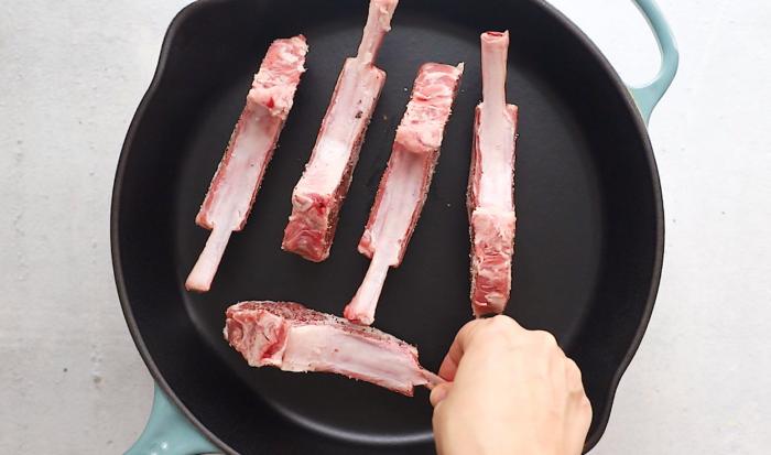 Lamb chops seared on the sides in a pan to render the fat