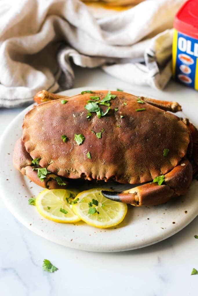 Steamed rock crab on a plate with cilantro and lemon