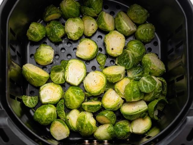 The Brussels sprouts in the air fryer basket before cooking