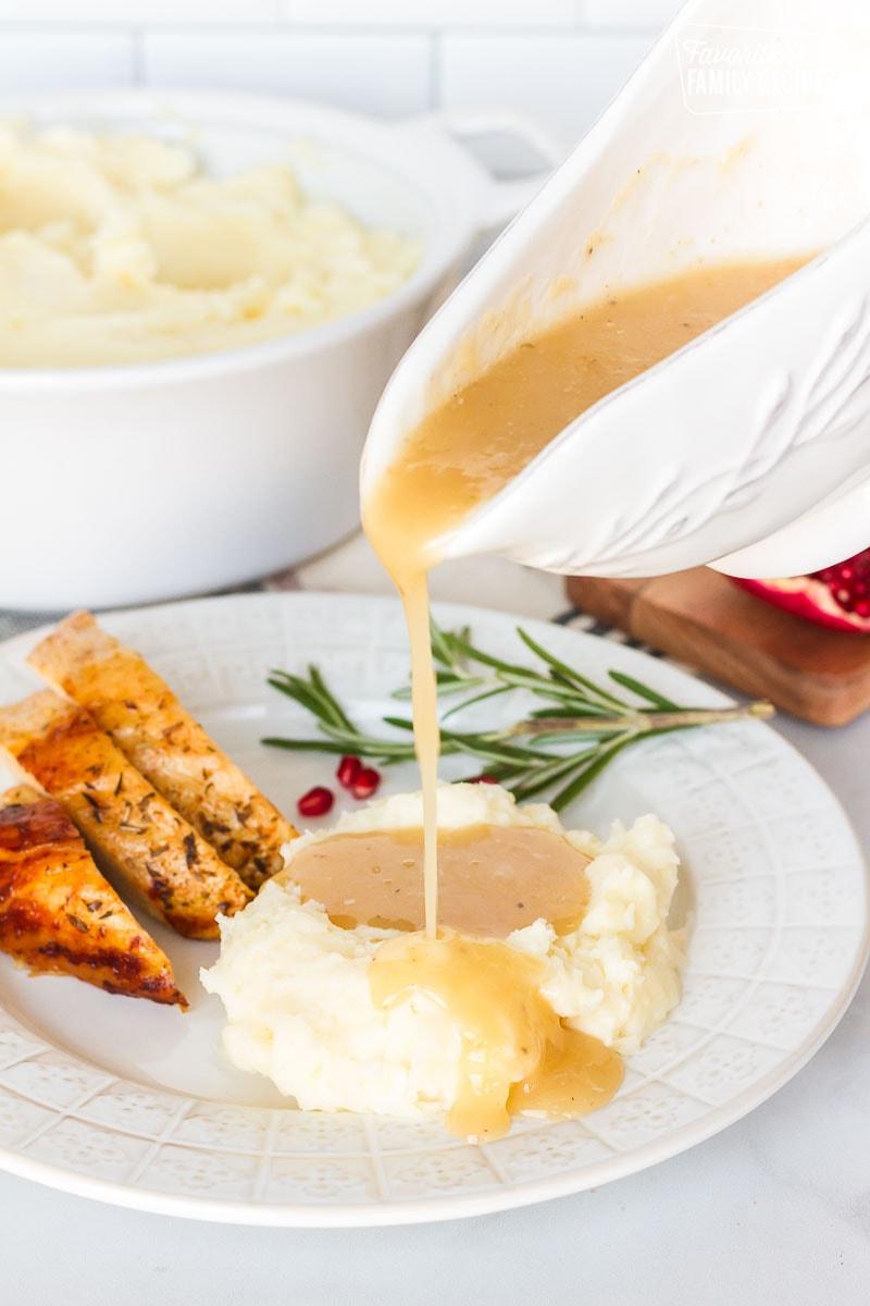 Turkey Gravy pouring on a plate of mashed potatoes and turkey