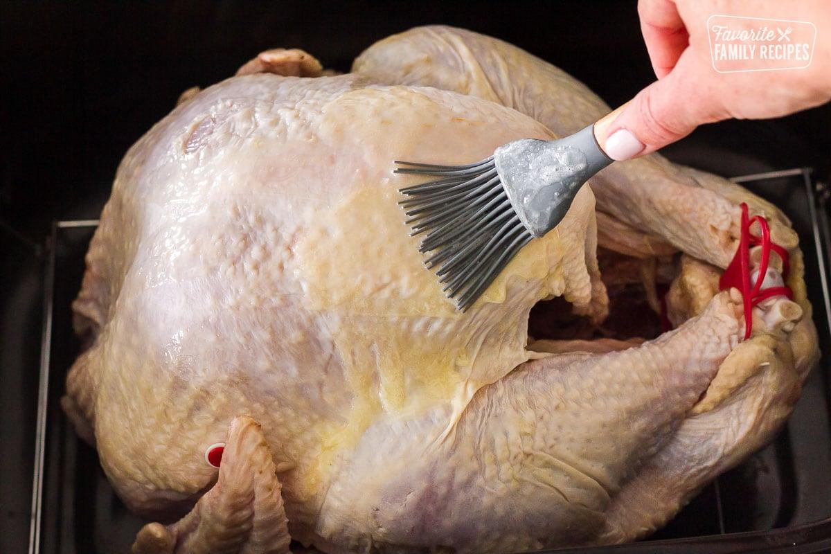Hand brushing butter on turkey