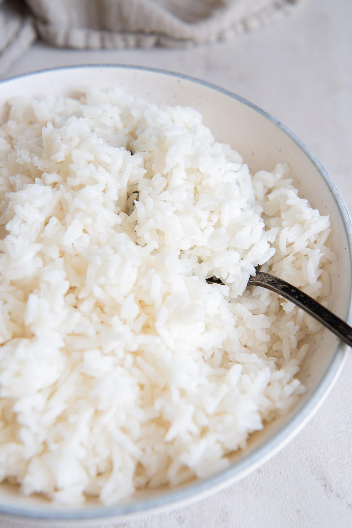 Cooked white rice in a bowl with a spoon