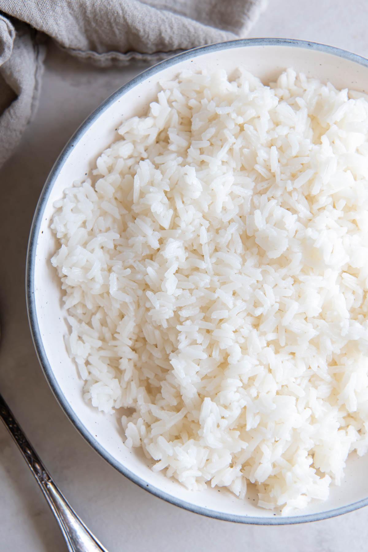 Cooked white rice in a white serving bowl